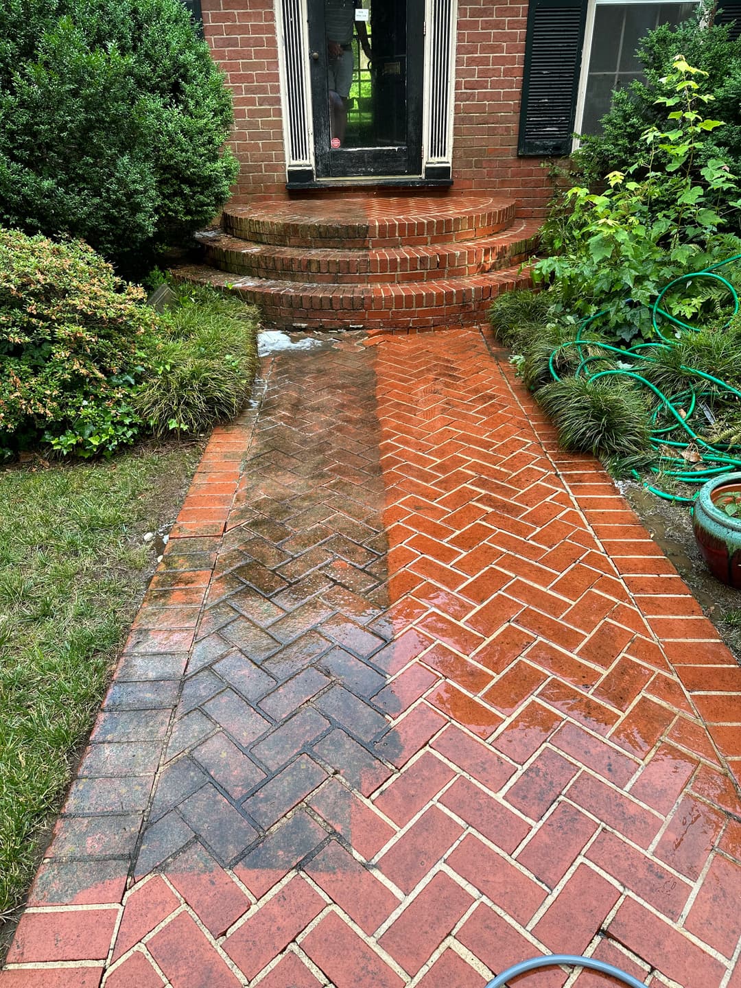 Clean vs. dirty brick walkway leading to a home, showcasing pressure washing results.